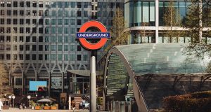 The Canary Wharf DLR sign with One Canada Square closely in the background