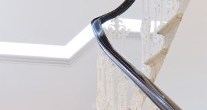 The staircase with intricate detailing on the banister