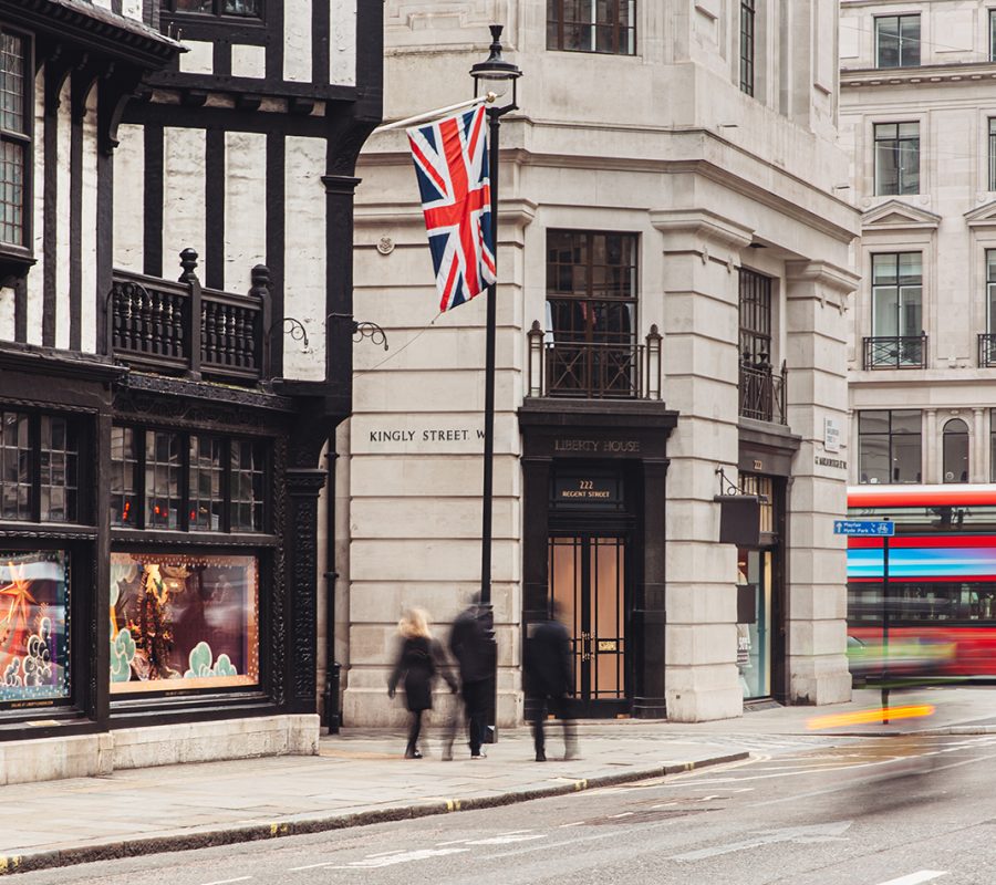 The exterior of the beautiful office space in Central London next to the Liberty of London store, with a London bus driving by.