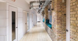 A corridor showing modern design against open brick walls at 24 Greville Street in London's EC1 district