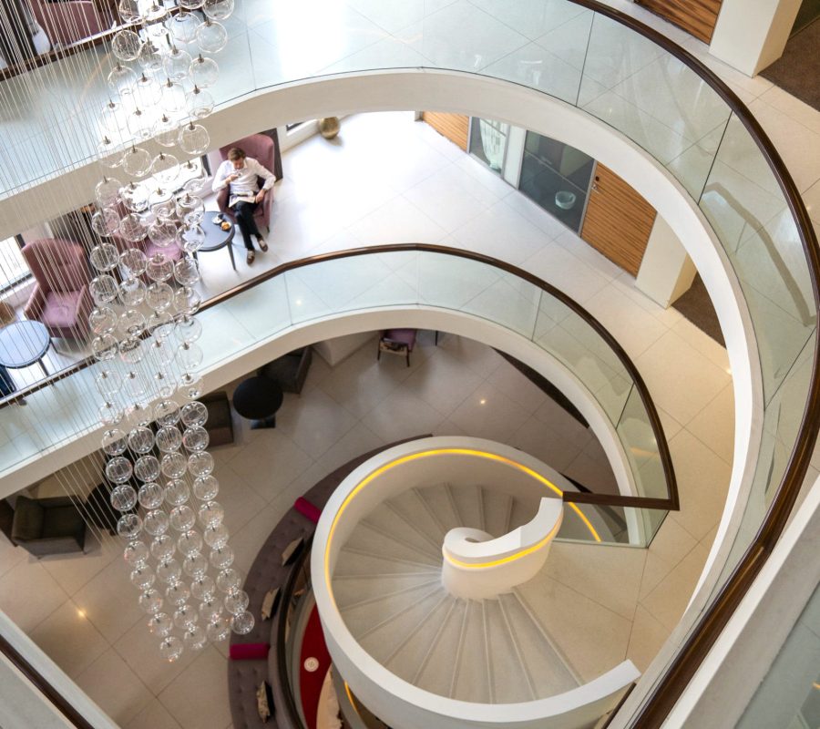Looking down at the spiral staircase and chandelier at the outstanding office space in London on Kensington High Street